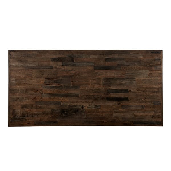 A rectangular wooden table top with black and brown wood planks.