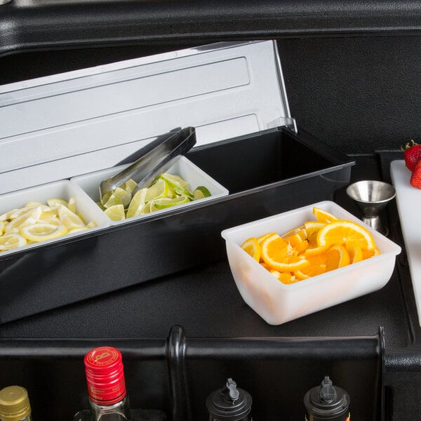 A white container with a variety of fruit and vegetables in a metal tray.