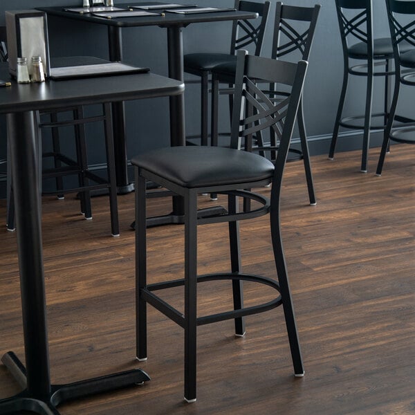 Lancaster Table & Seating Black Finish Cross Back Bar Stool with 2 1/2" Black Vinyl Padded Seat - Detached Seat
