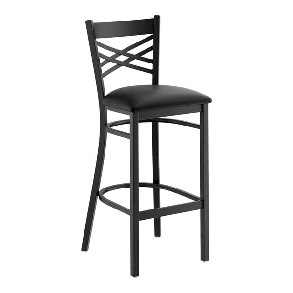 A black metal bar stool with a cross back design and a black vinyl padded seat.