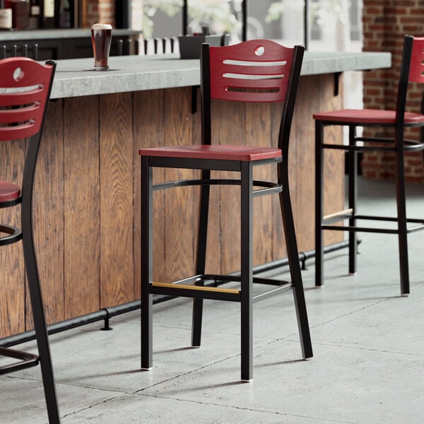 A Lancaster Table & Seating bar stool with a mahogany seat and back.