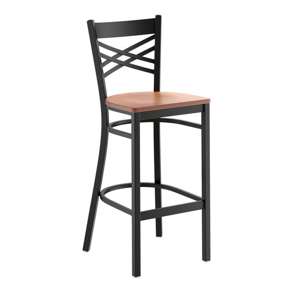A black metal bar stool with a cross back design and an antique walnut wood seat.