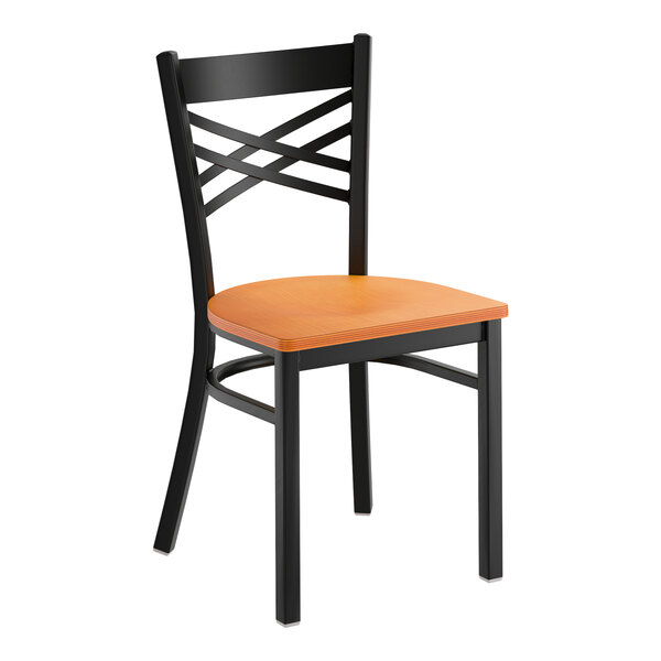 A black metal cross back chair with a cherry wood seat.