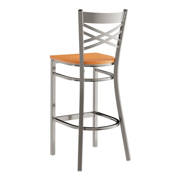 A metal bar stool with a cross back design and a cherry wood seat.