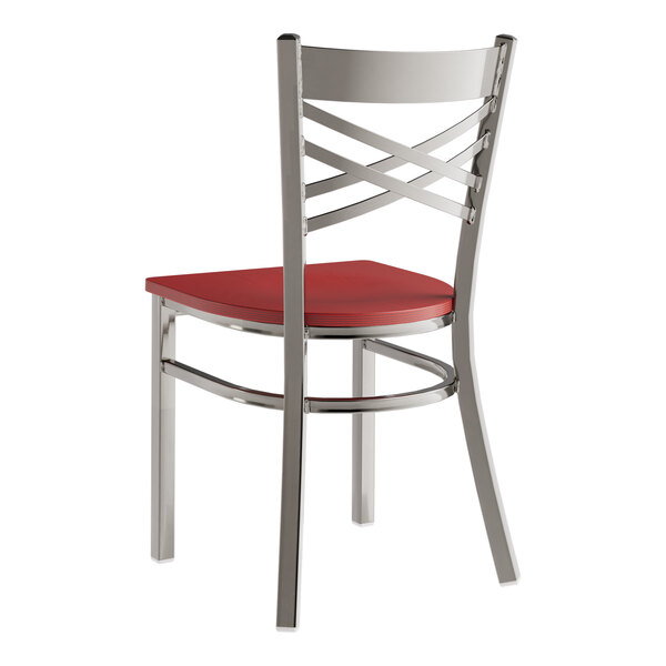 A Lancaster Table & Seating red metal cross back chair with a mahogany wood seat.