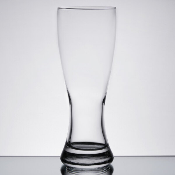 An Anchor Hocking Rim Tempered Pilsner Glass with a clear surface and a shadow.