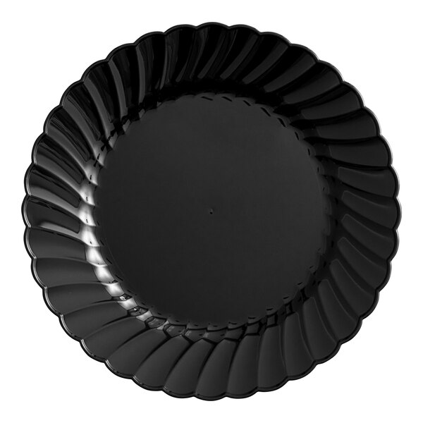 A close-up of a WNA Comet Classicware black plastic plate with a scalloped edge.
