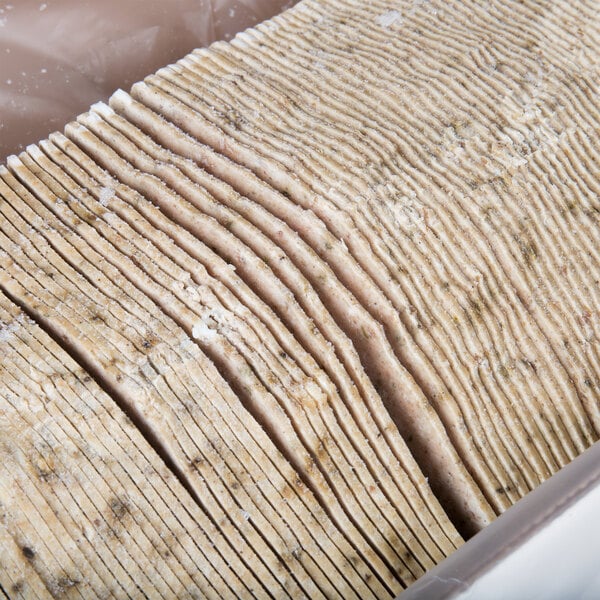 A stack of thin slices of fully cooked Kronos beef and lamb gyros on a white background.