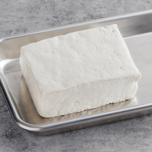 A large white block of Franklin Farms Organic Non-GMO Firm Tofu on a metal tray.
