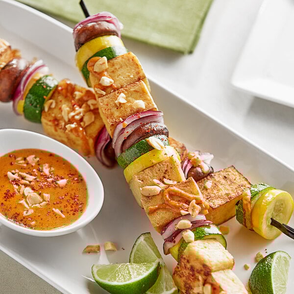 A plate of grilled vegetables with dipping sauce.