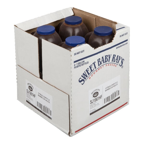 A cardboard box containing four large plastic bottles with blue caps, partially visible, labeled as Sweet Baby Ray's Citrus Chipotle Barbecue Sauce.
