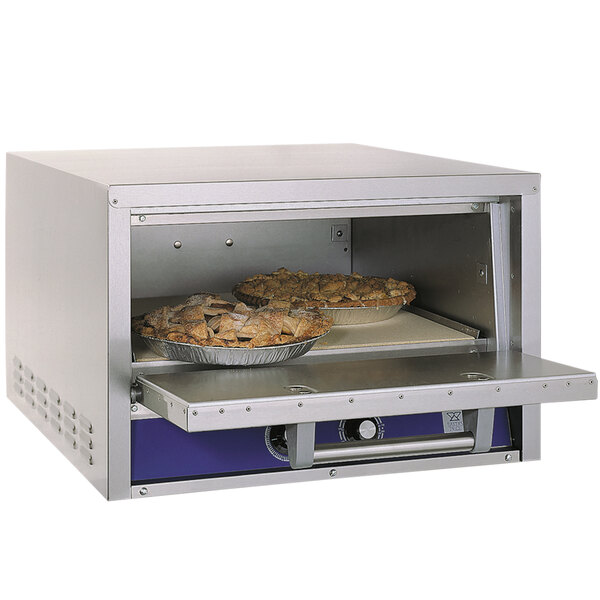 A Bakers Pride countertop oven with pies baking inside.