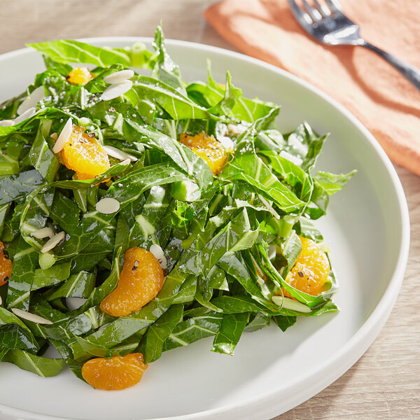 A plate of food with bunched collard greens and oranges.