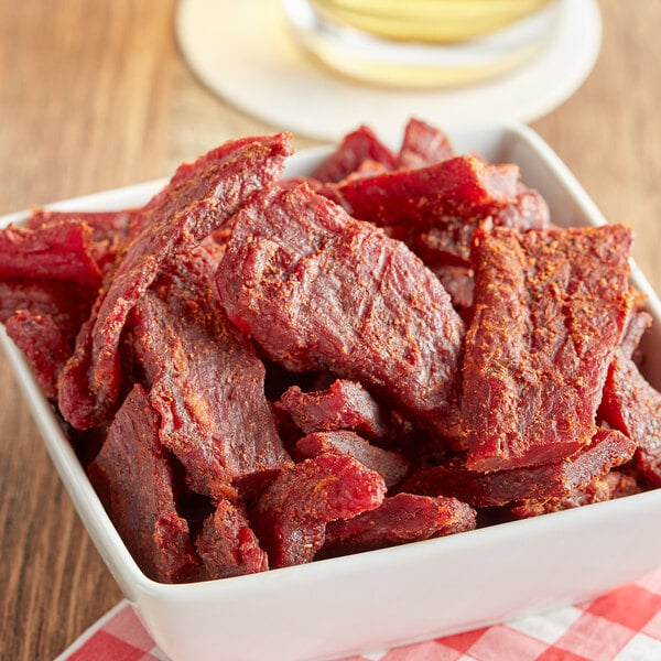 A bowl of Uncle Mike's Original Beef Jerky on a table.