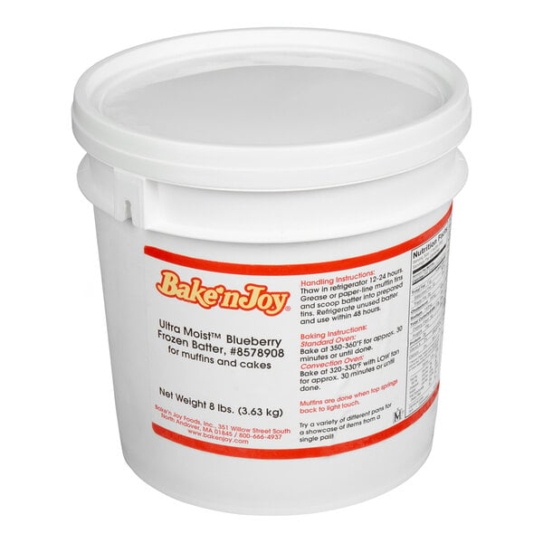 A white plastic pail with a lid, labeled 'Bake'n Joy Ultra Moist Blueberry Frozen Batter' for muffins and cakes, with baking instructions and nutritional information visible on the side.