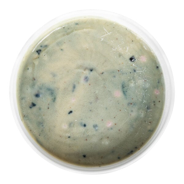 A round container filled with a thick, pale batter that has visible dark and light specks throughout.