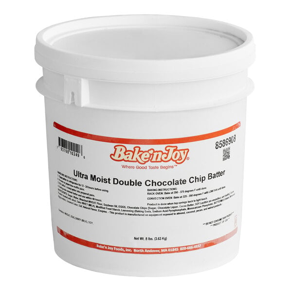 A large white plastic tub labeled 'Bake'n Joy Ultra Moist Double Chocolate Chip Batter' with baking instructions and product information printed on the front.