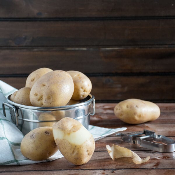 A bowl of White Chef potatoes on a wooden table.