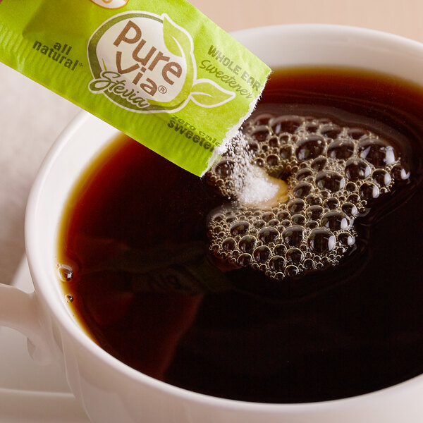 Packet of stevia being poured into coffee