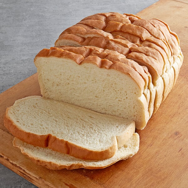 A Wholesome Harvest White Panini Bread loaf on a cutting board.