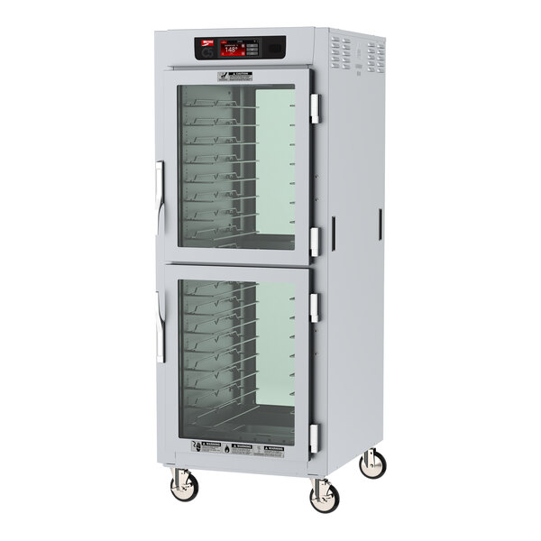 A large white holding cabinet with clear glass Dutch doors.