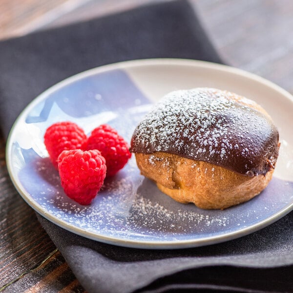 A Rich's unfilled cream puff pastry shell with raspberries on a plate.