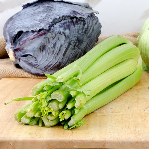 A bunch of fresh celery on a cutting board.