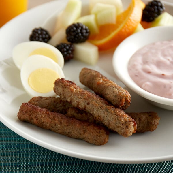 A plate with a hard boiled egg, fruit, and a Jones Dairy Farm turkey sausage link.