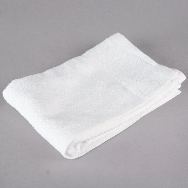 An open white Oxford bath towel folded on a gray surface.