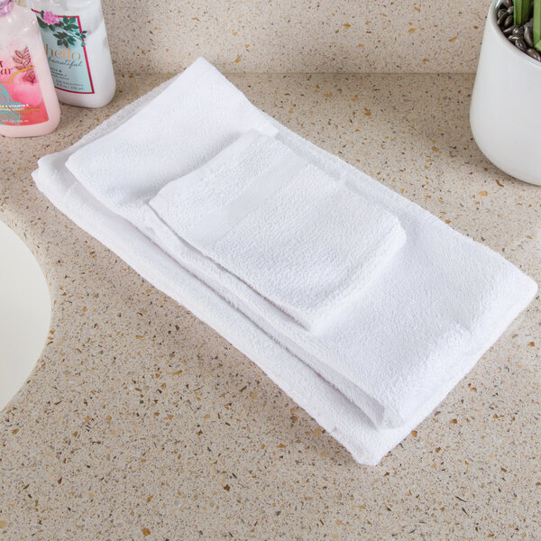 A stack of Oxford white bath towels on a counter.