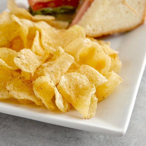 A plate with a sandwich and Route 11 Dill Pickle Potato Chips.