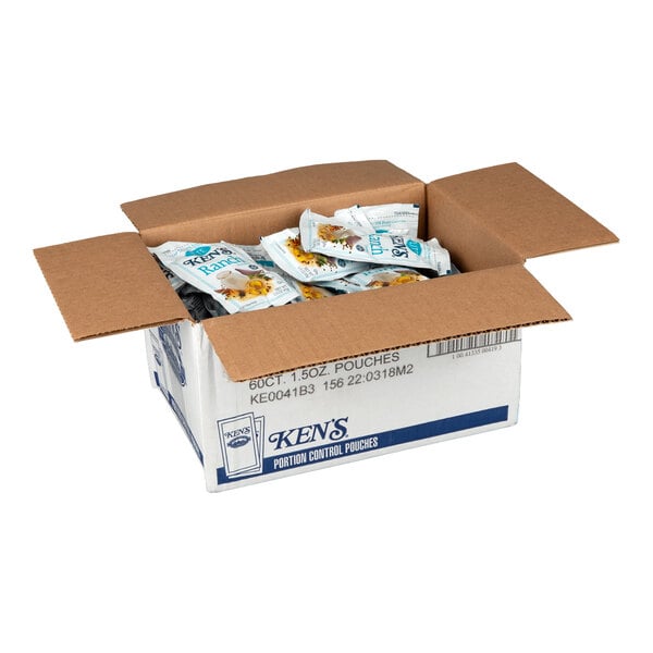 An open cardboard box containing multiple individual packets of Ken's Lite Ranch Dressing.