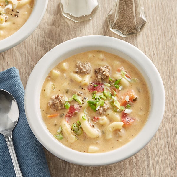 A white bowl of Spring Glen Cheeseburger Chowder with meat and vegetables.