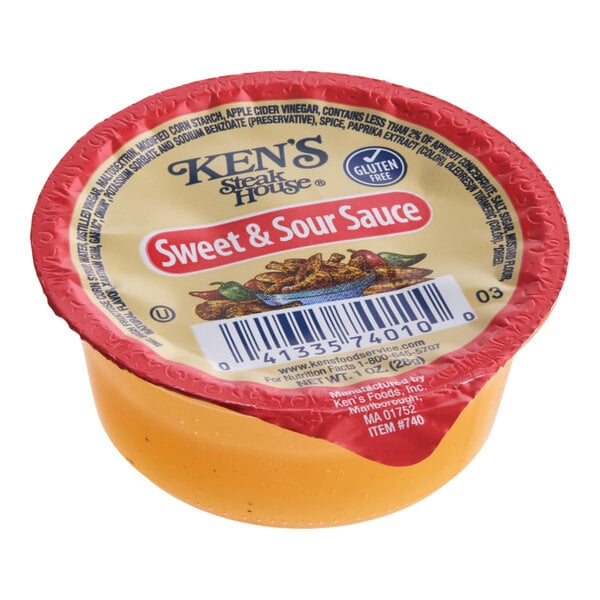 A single-serve portion cup of Ken's Steak House Sweet & Sour Sauce.