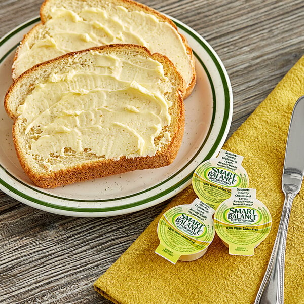 A plate with a piece of bread and a Smart Balance butter spread cup on it.