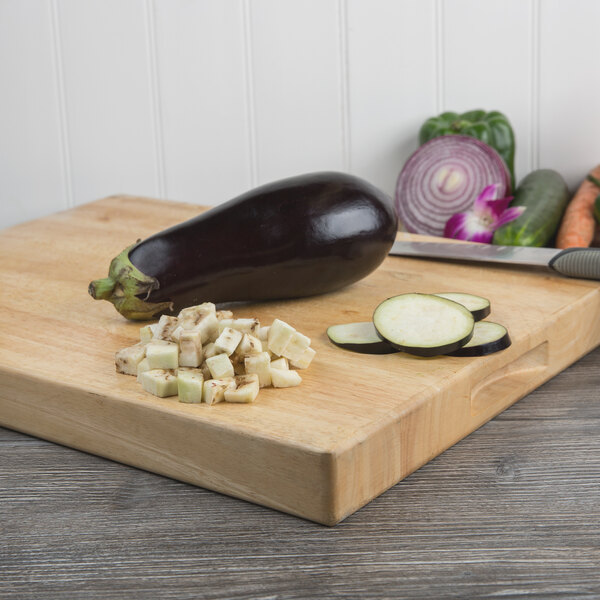 A cutting board with sliced eggplant and other vegetables.