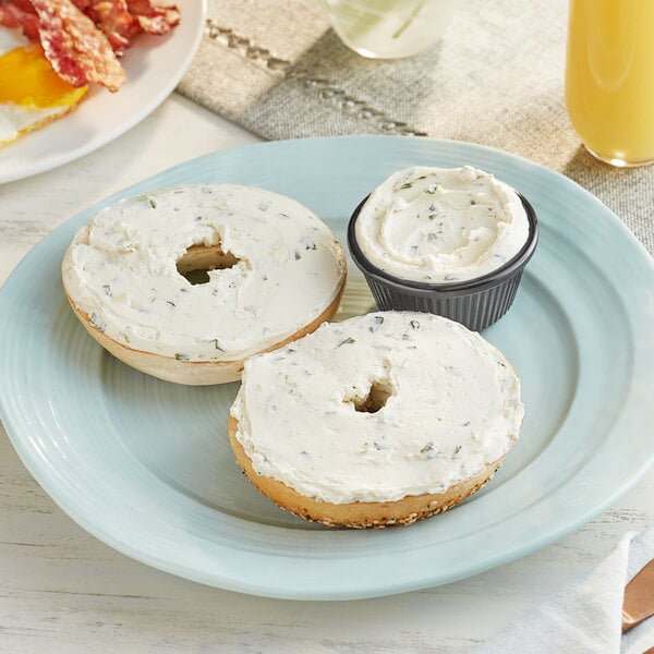 A plate with a bagel with Chive Cream Cheese Spread and eggs.