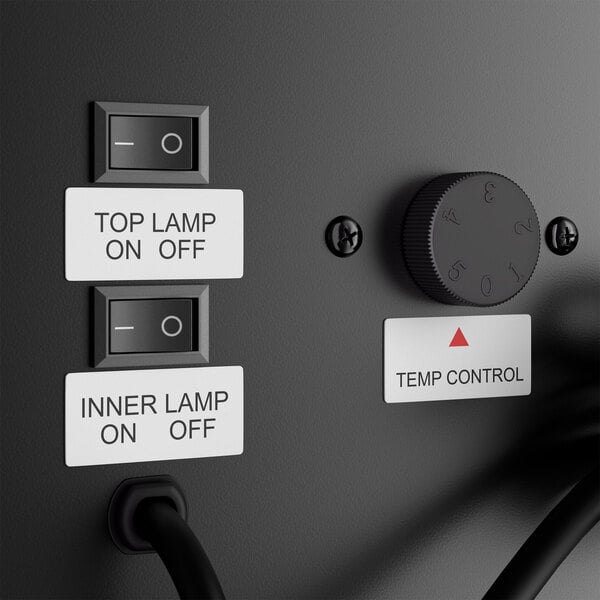 A close-up view of two labeled switches for top and inner lamps, a temperature control dial, and a power cord on a black panel.