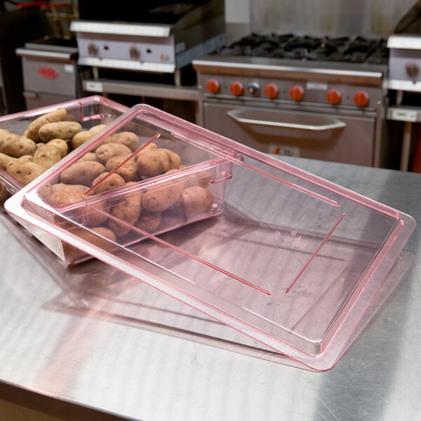 A red Cambro flat lid on a plastic food storage box with potatoes inside.