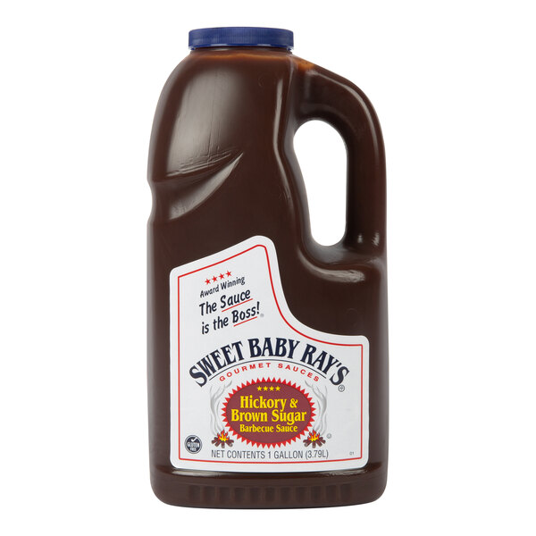 A large plastic jug with a handle and blue cap, filled with dark brown barbecue sauce and labeled 'Sweet Baby Ray's Hickory & Brown Sugar Barbecue Sauce.'