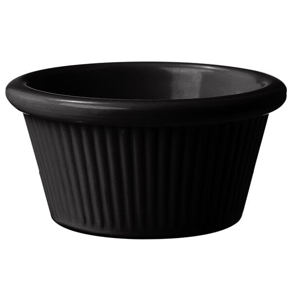 A black fluted melamine ramekin with a rim.