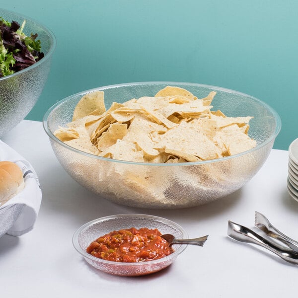 A pebbled serving bowl filled with chips.