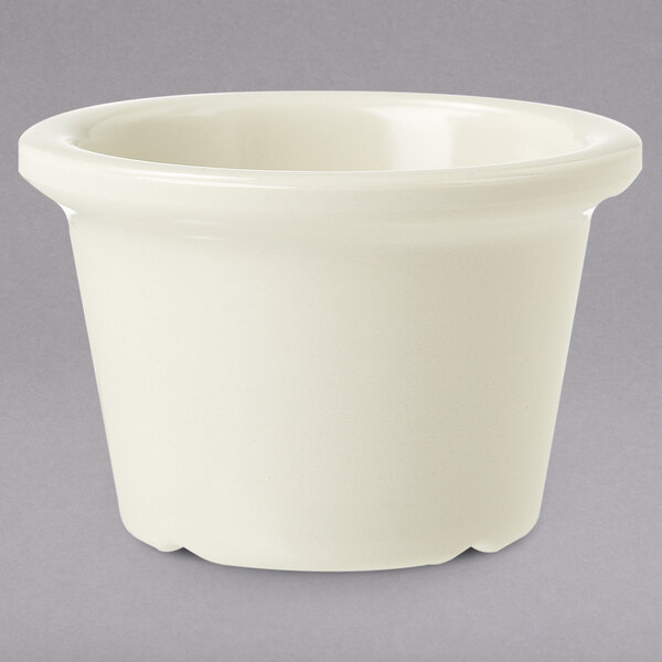 A ivory smooth melamine ramekin with a round rim on a gray background.