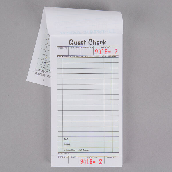 An Adams white guest check book on a counter with writing on white paper.