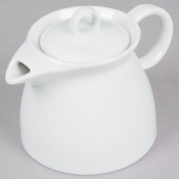 An Arcoroc white ceramic teapot with a lid and handle.