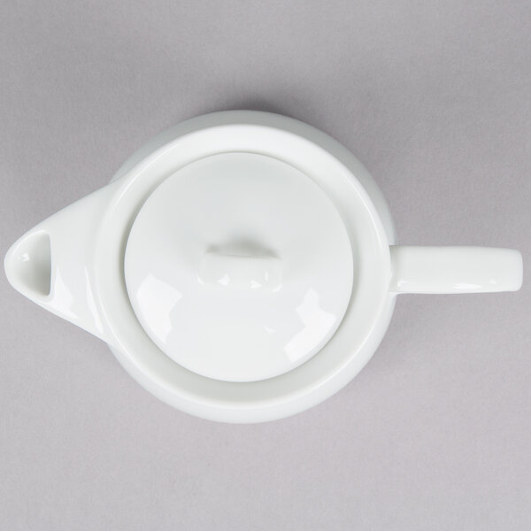 An Arcoroc white teapot with a lid.