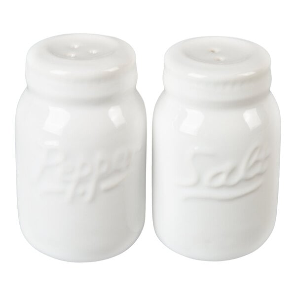 Two white ceramic shakers shaped like mason jars, labeled 'Salt' and 'Pepper' in raised lettering.