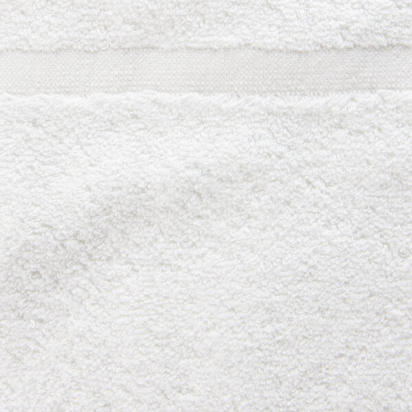 A close up of a white Oxford Belleeza hotel bath mat.