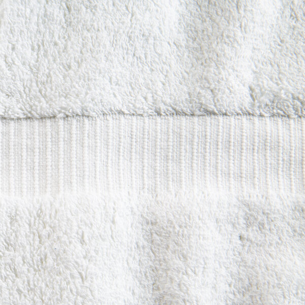 A close up of an Oxford Belleeza white bath towel with a white stripe.