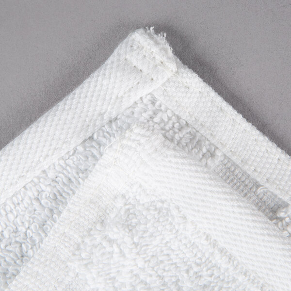 A close up of a white Oxford Belleeza wash cloth with a folded corner.